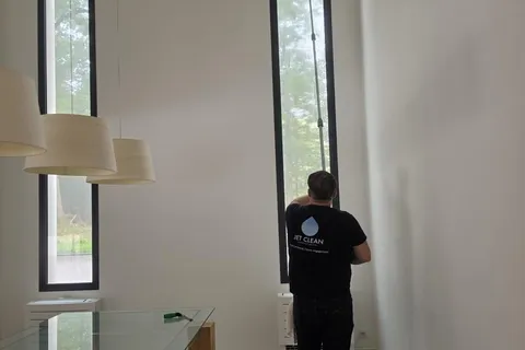 Intervenant Jet Clean nettoyant une grande baie vitrée chez un particulier
